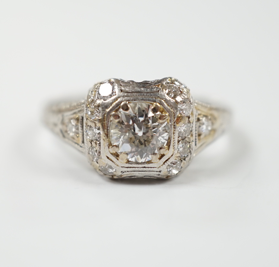 A mid 20th century engraved white metal and single stone diamond set ring, the pierced setting set with twenty small brilliants, size M, gross weight 4.3 grams